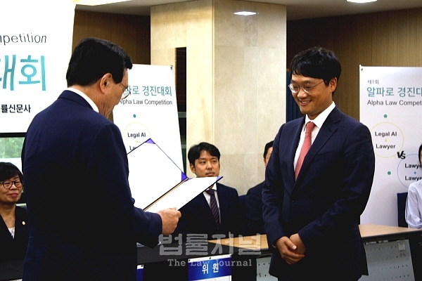 1등부터 3등까지 모두 AI팀이 휩쓴 가운데 김형우 변호사가 우승을 차지했다. 사진은 김형우 변호사가 강현중 사법정책연구원장으로부터 상을 받고 있는 모습.